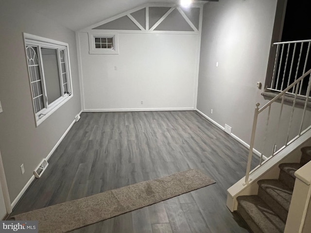 unfurnished dining area with lofted ceiling and dark hardwood / wood-style flooring