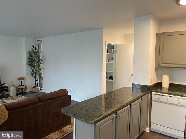 kitchen featuring dishwasher, kitchen peninsula, and dark stone counters