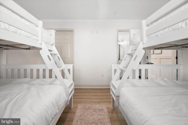 bedroom featuring ornamental molding and wood-type flooring