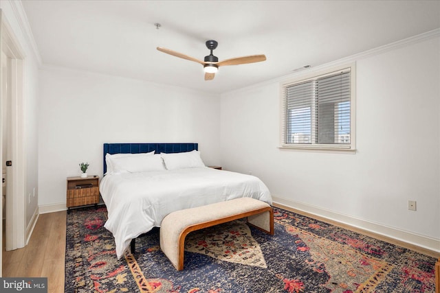 bedroom with ceiling fan, crown molding, and wood-type flooring