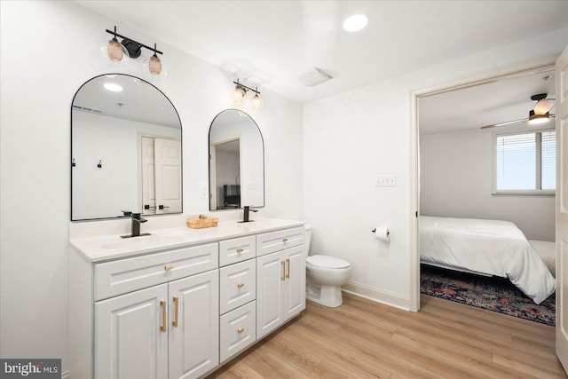 bathroom with ceiling fan, wood-type flooring, toilet, and vanity