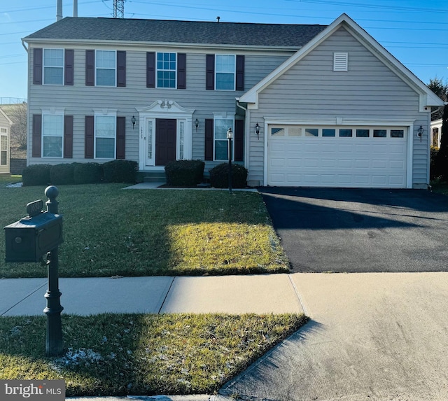 colonial inspired home with a garage and a front yard