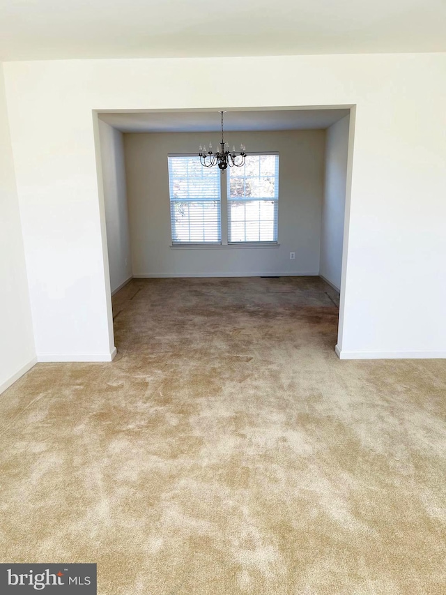 unfurnished dining area with light carpet and an inviting chandelier