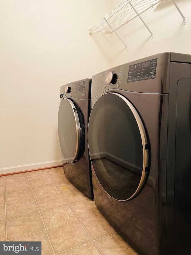 washroom featuring light tile patterned floors and washer and clothes dryer