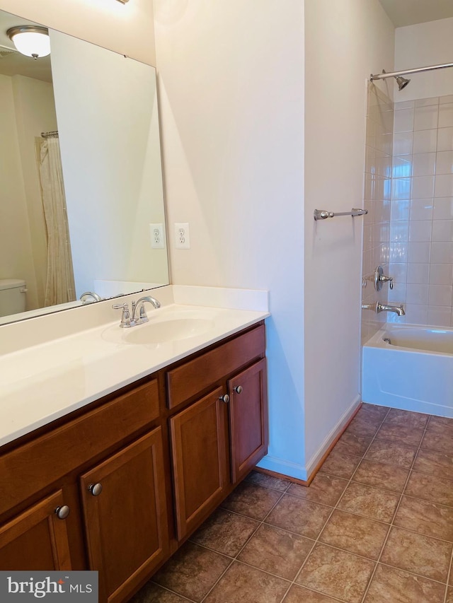 full bathroom with tiled shower / bath combo, vanity, and toilet