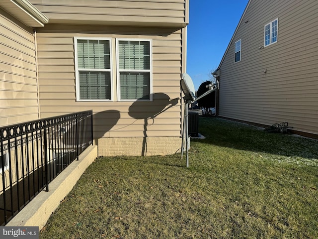 view of home's exterior with central AC unit and a lawn