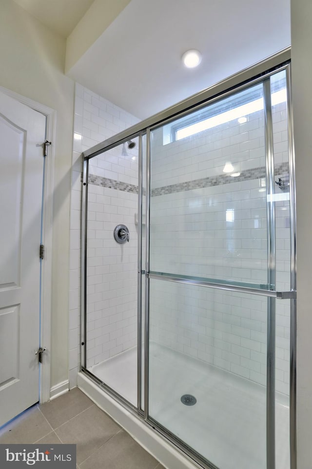 bathroom featuring a shower with door and tile patterned floors