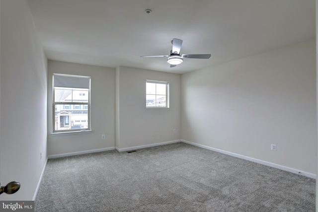 spare room featuring light carpet and ceiling fan