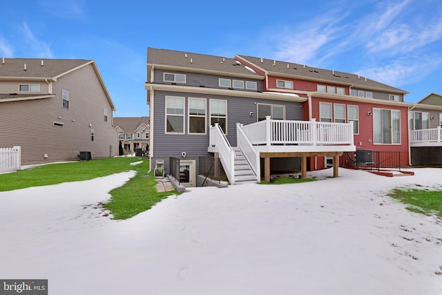 rear view of property featuring a deck, central air condition unit, and a yard