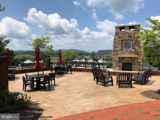 view of patio / terrace with a mountain view and an outdoor stone fireplace