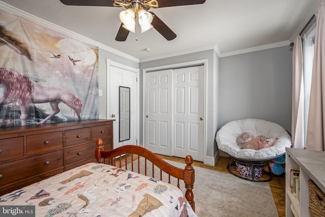 bedroom featuring ceiling fan, ornamental molding, a closet, and hardwood / wood-style flooring