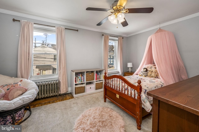 bedroom featuring multiple windows, radiator heating unit, ceiling fan, and ornamental molding