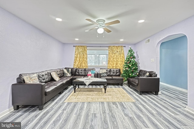 living room with wood-type flooring and ceiling fan