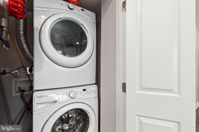 clothes washing area with laundry area and stacked washer / dryer