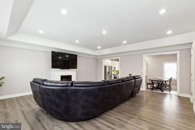 living area with light wood-style floors, a fireplace, baseboards, and recessed lighting