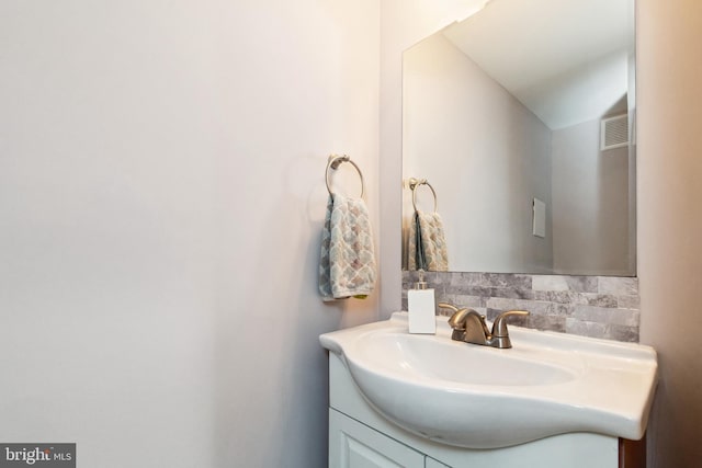 bathroom with visible vents, backsplash, and vanity