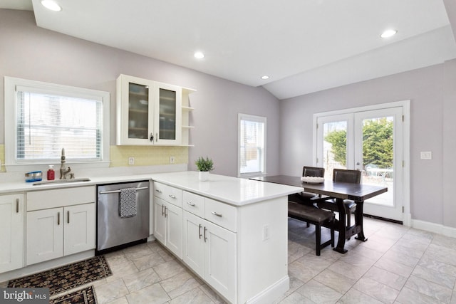 kitchen featuring a peninsula, a sink, light countertops, dishwasher, and open shelves