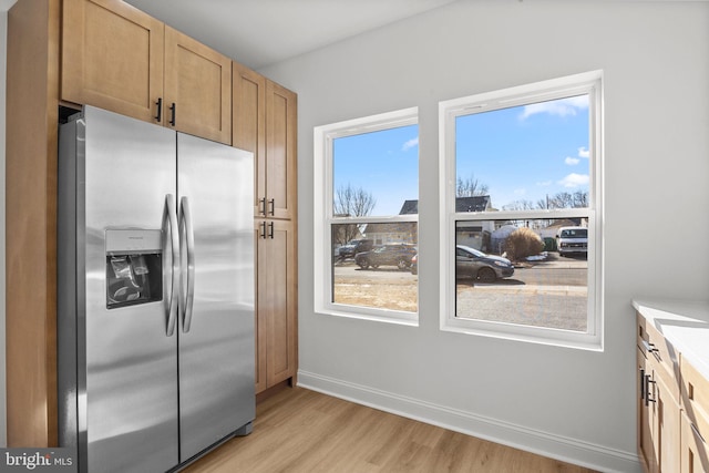 kitchen featuring light hardwood / wood-style flooring, plenty of natural light, and stainless steel refrigerator with ice dispenser