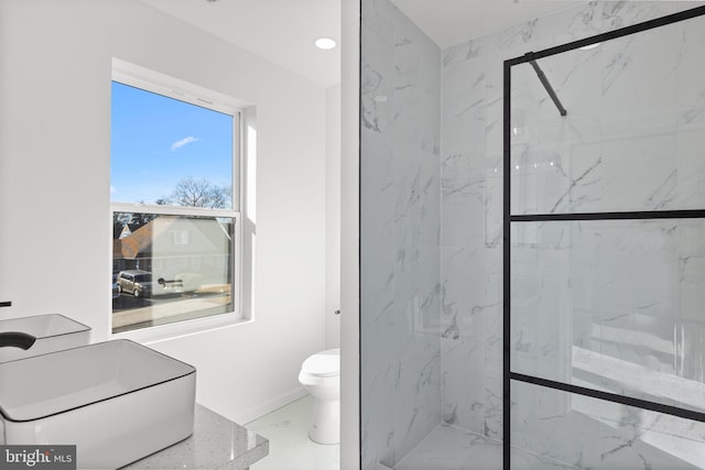 bathroom with a shower with shower door and toilet