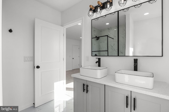 bathroom featuring a shower with door and vanity