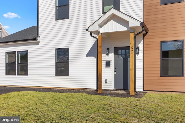 view of exterior entry featuring a yard