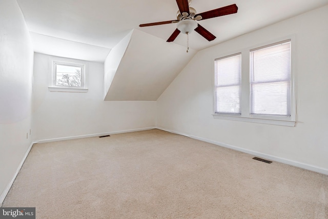 additional living space featuring vaulted ceiling, ceiling fan, and light colored carpet