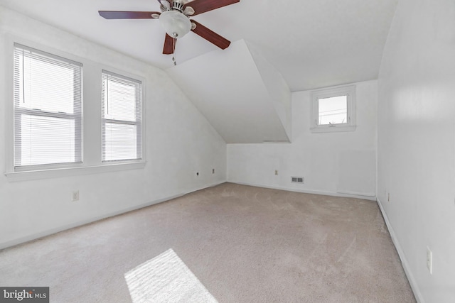 additional living space featuring light carpet, ceiling fan, and vaulted ceiling