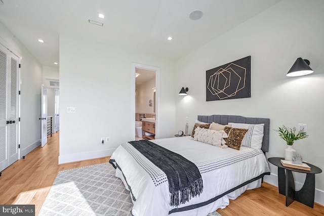 bedroom featuring light hardwood / wood-style floors and ensuite bath