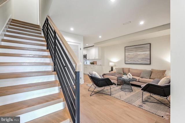 stairs featuring hardwood / wood-style floors