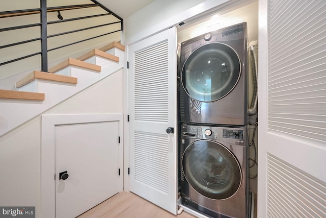 laundry area featuring light hardwood / wood-style floors and stacked washer / drying machine