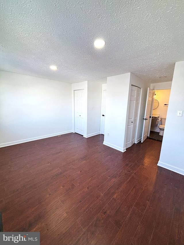 spare room with dark wood-type flooring and a textured ceiling