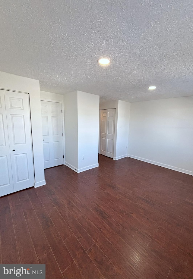 interior space with a textured ceiling and dark hardwood / wood-style flooring