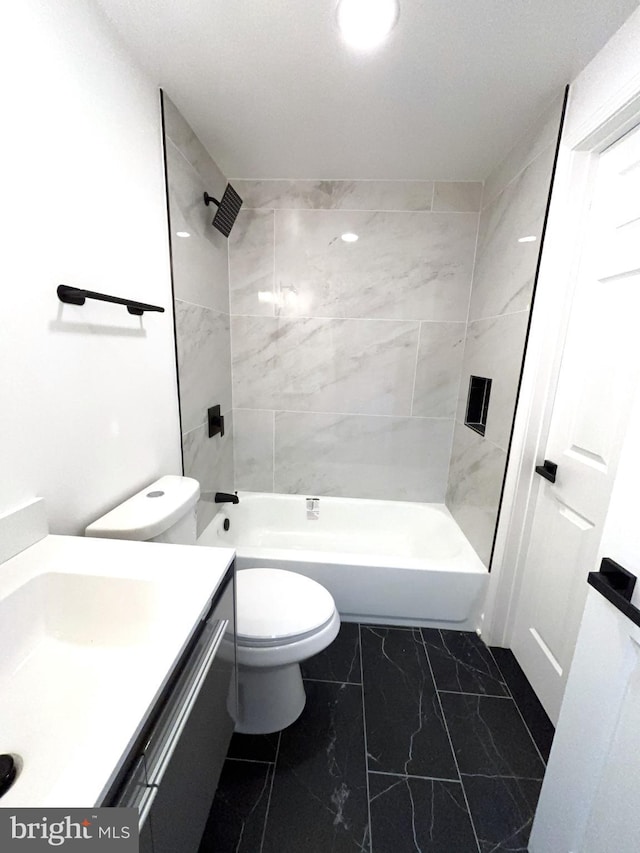 full bathroom featuring toilet, tiled shower / bath, and vanity