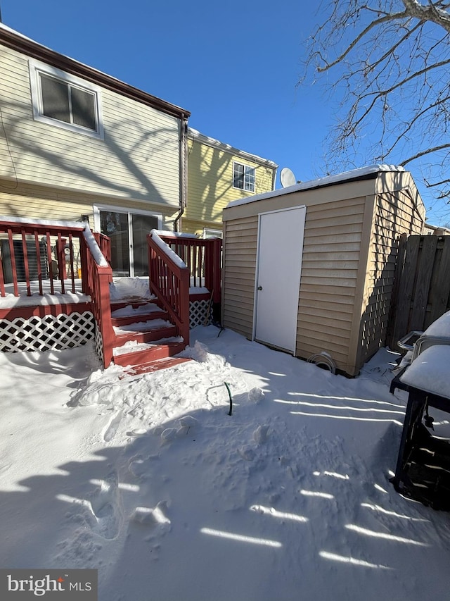 snow covered deck featuring a storage unit