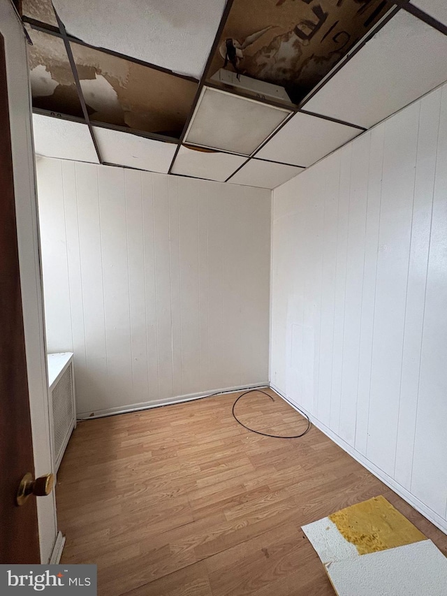 basement featuring basketball hoop, wood-type flooring, and a drop ceiling