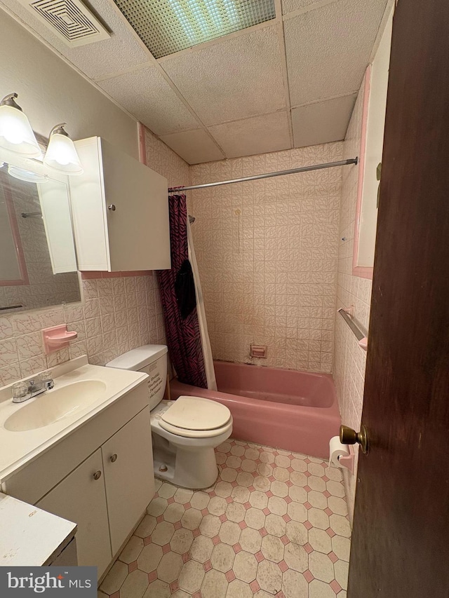 full bathroom featuring shower / tub combo, a paneled ceiling, vanity, and toilet