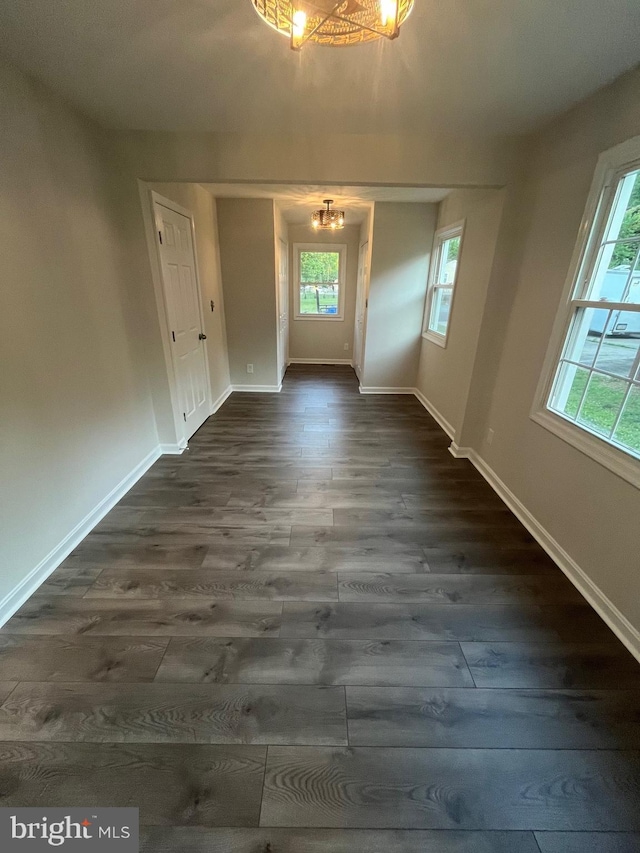 unfurnished dining area with dark hardwood / wood-style flooring and a chandelier