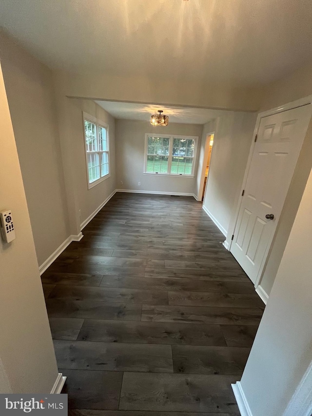 interior space with dark wood-type flooring and a chandelier