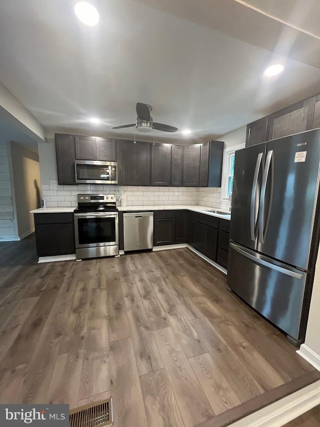 kitchen featuring tasteful backsplash, sink, light hardwood / wood-style floors, and appliances with stainless steel finishes