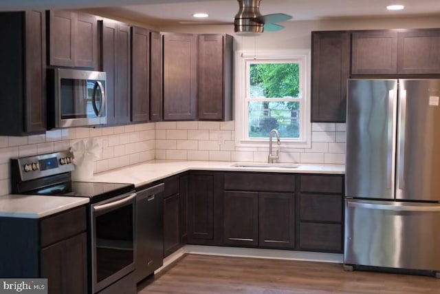 kitchen featuring stainless steel appliances, dark hardwood / wood-style flooring, sink, and dark brown cabinetry