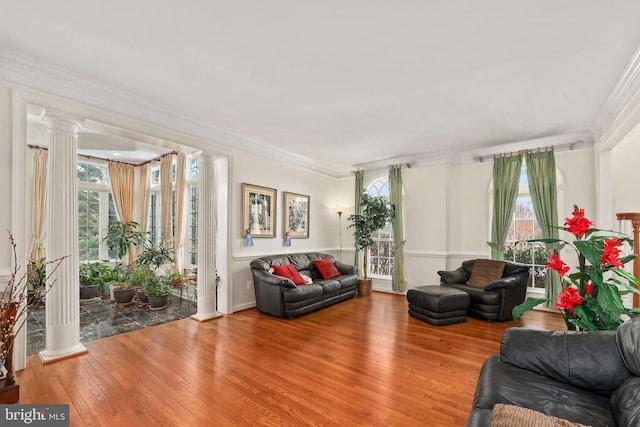 living room with ornate columns, crown molding, and hardwood / wood-style flooring