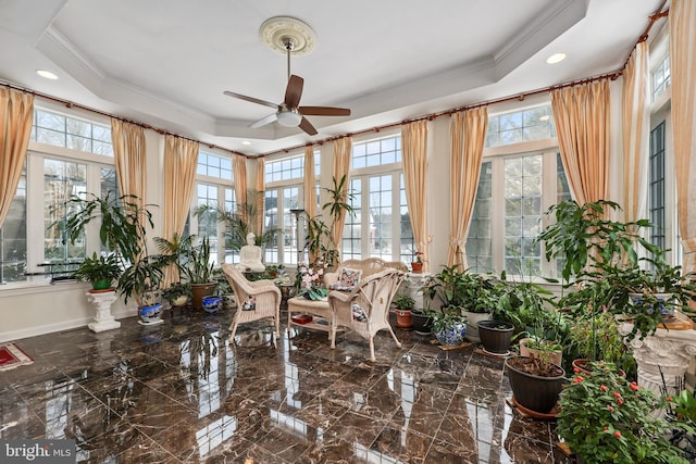 sunroom / solarium featuring ceiling fan and a raised ceiling