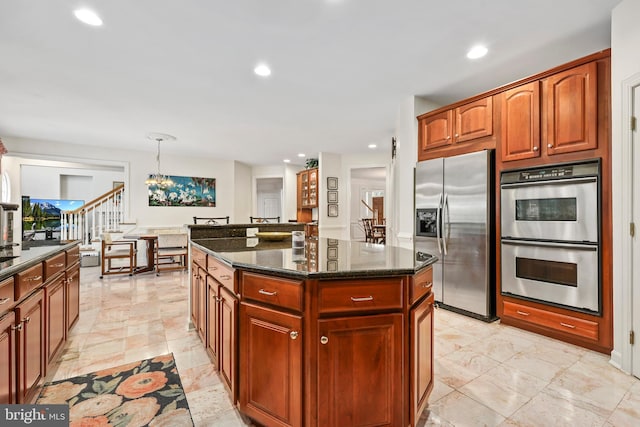 kitchen with pendant lighting, appliances with stainless steel finishes, a kitchen island, dark stone countertops, and an inviting chandelier