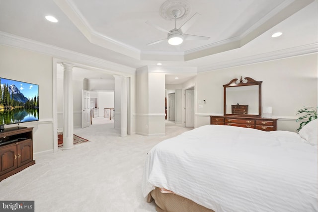 carpeted bedroom featuring ceiling fan, a tray ceiling, ornamental molding, and ornate columns