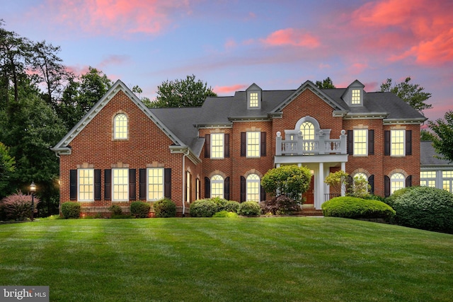 colonial-style house with a lawn and a balcony