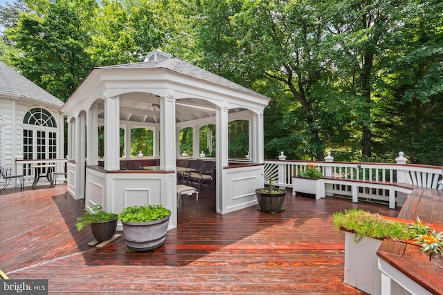 wooden deck with a gazebo and a sunroom