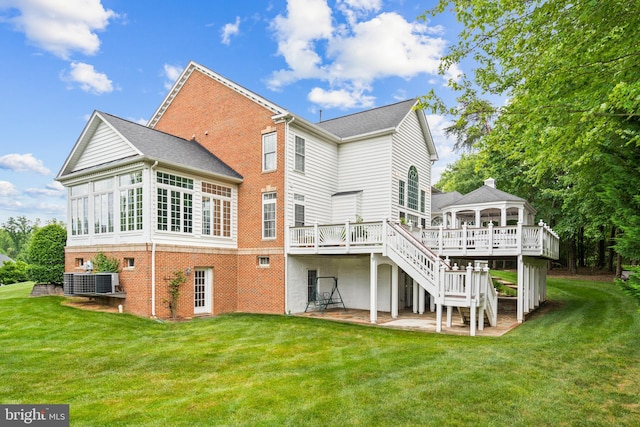 rear view of house featuring a gazebo, a wooden deck, a patio, a lawn, and central air condition unit