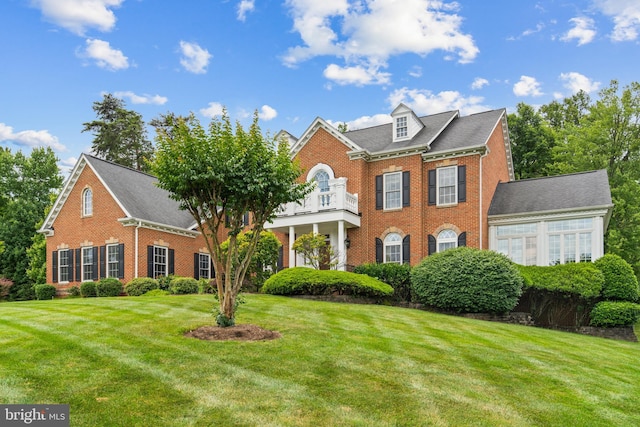 colonial home with a front lawn and a balcony