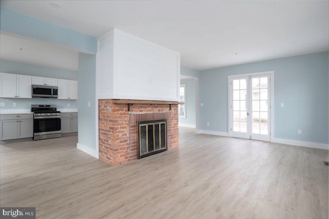 unfurnished living room featuring a fireplace and light hardwood / wood-style floors