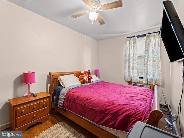 bedroom featuring ceiling fan, cooling unit, and dark hardwood / wood-style floors